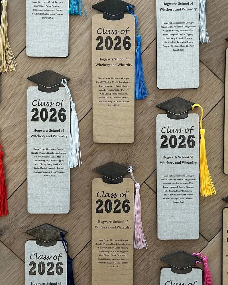 Laser cut graduation bookmarks sitting on an oak table